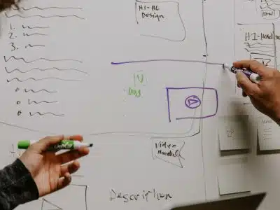 two people drawing on whiteboard